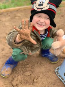 smiling child with dirty hands
